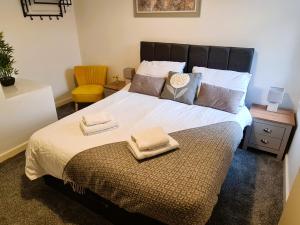 ブラックプールにあるTower Views 2 Bedroom House with Private Parkingの大きなベッドとタオル2枚のある寝室