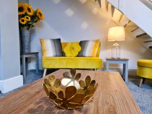 ein Wohnzimmer mit einem Tisch und einem gelben Sofa in der Unterkunft Tower Views 2 Bedroom House with Private Parking in Blackpool