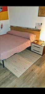 1 cama con cabecero de madera y mesita de noche en CASA TRAVELLERS GEODAP, en Nápoles