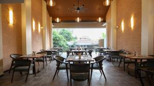 a restaurant with tables and chairs and a clock on the ceiling at Golden Fields Resort in Mulshi