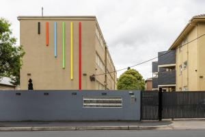 un edificio con banderas de colores a su lado en Bright and Modern Space with a Balcony and Parking en Melbourne