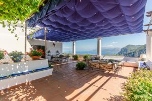 uma vista do pátio de uma casa com um telhado azul em Villa Ginestra by Elite Villas em Capri