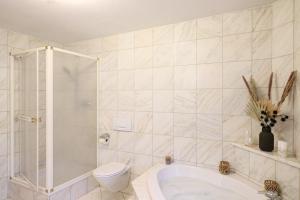 a bathroom with a toilet and a bath tub at Naturtalente Berghaus - Apartment 2 in Innerschwand am Mondsee +19 photos