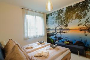 two beds in a room with a painting on the wall at Naturtalente Villa in Sankt Johann in der Haide
