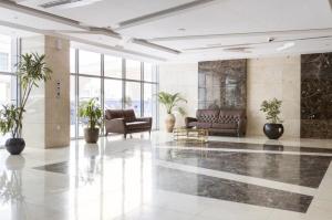 un vestíbulo con sofás y plantas en un edificio en 50% OFF Summer Offert, Nice w/ Balcony & Pool View en Dubái