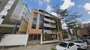 um edifício com carros estacionados em frente em Quarto de Casal em Apartamento - Belo Horizonte - Buritis em Belo Horizonte