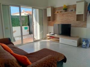 a living room with a couch and a flat screen tv at Villa Feliz in Abades