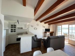 una cucina e un soggiorno con pareti bianche e soffitti in legno di ES CASTELL 1 by SOM Menorca a Fornells