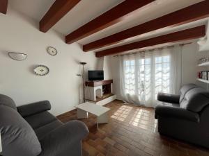 ein Wohnzimmer mit zwei Sofas und einer Uhr an der Wand in der Unterkunft ES CASTELL 1 by SOM Menorca in Fornells