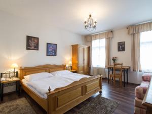 Un dormitorio con una gran cama de madera y una mesa. en Hotel Šumava, en Vyšší Brod