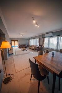 una gran sala de estar con mesa de madera y sillas. en Ginza Villa Sapanca, en Sapanca