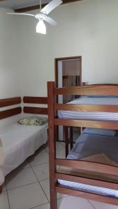 a bedroom with two bunk beds and a ceiling fan at Céu Azul Pousada in Arraial d'Ajuda