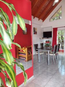comedor con pared roja, mesa y sillas en AltoRojo en Villa Elisa