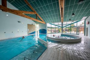 een groot binnenzwembad met een hot tub bij Camping Les Vosges du Nord in Oberbronn