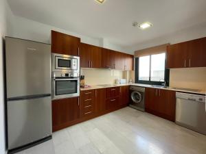 una cocina con armarios de madera y electrodomésticos de acero inoxidable en BAHIA 28 by SOM Menorca en Fornells