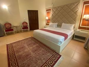 ein Schlafzimmer mit einem großen Bett und einem Teppich in der Unterkunft Margalla Hills Residency Islamabad Guest House in Islamabad