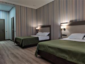 MisailovoにあるKA Royal Hotel BOUTIQUE - КА Роял Бутик Отельのホテルルーム ベッド2台&緑のシーツ付