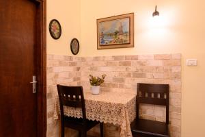 a table with two chairs and a vase of flowers on it at My Place in the Colony in Zikhron Ya'akov