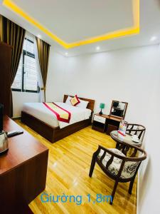 a hotel room with a bed and a table and a chair at Saphia Hotel Huế (sapphire Hotel 2) in Hue