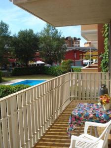 een veranda met een wit hek en een tafel en stoelen bij Wonderful apartment with terrace and pool in Porto Santa Margherita di Caorle