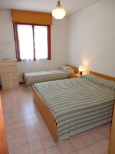 een kamer met drie bedden in een kamer bij Wonderful apartment with terrace and pool in Porto Santa Margherita di Caorle