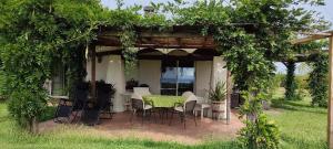 a patio with a table and chairs under a pergola at Villa Fonte Tartaruga Trevignano Romano in Trevignano Romano
