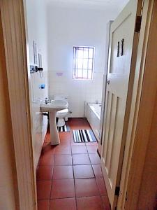 a bathroom with a sink and a toilet and a tub at Shark shacks in Mossel Bay