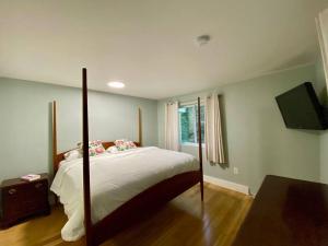 a bedroom with a large bed and a television at White Mountain Retreat in Thornton