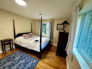 a bedroom with a four poster bed and a window at White Mountain Retreat in Thornton