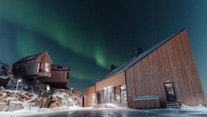 un bâtiment avec l'aurore dans le ciel dans l'établissement Hattvika Lodge, à Ballstad