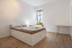 ein Schlafzimmer mit einem Bett in einem weißen Zimmer in der Unterkunft NEXT HOME - FREE Parking & WiFi - Badewanne in Duisburg