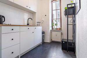 eine Küche mit weißen Schränken und einem Waschbecken in der Unterkunft NEXT HOME - FREE Parking & WiFi - Badewanne in Duisburg