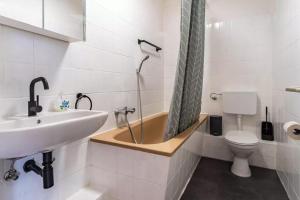 a bathroom with a tub and a sink and a toilet at NEXT HOME - FREE Parking & WiFi - Badewanne in Duisburg