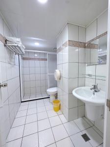a white bathroom with a sink and a toilet at Meng Jing Hotel in Zhongli