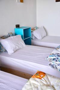 3 camas en una habitación con paredes blancas en Surf House Desert Point, en Tiguert