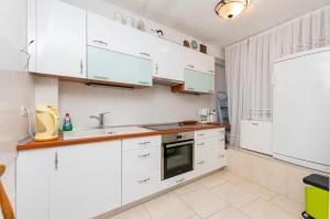 a kitchen with white cabinets and a sink at House Stipan in Vinišće