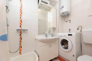 a small bathroom with a washing machine and a sink at House Stipan in Vinišće