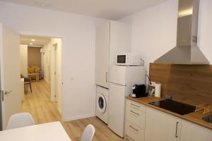 a kitchen with a white refrigerator and a microwave at VUT PEDRO LUXURY in Padrón