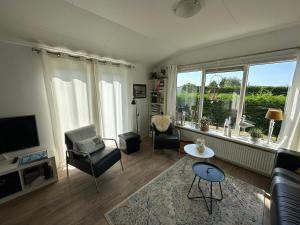 a living room with a couch and chairs and a tv at Effe Niks in Buren