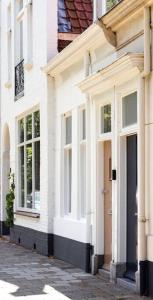 Casa blanca con puerta y ventanas en una calle en Slapen bij Zoet & Zilt en Middelburg