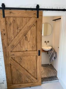uma porta de madeira numa casa de banho com um lavatório em Slapen bij Zoet & Zilt em Middelburg