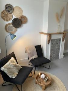 Slapen bij Zoet & Zilt في ميدلبورغ: غرفة معيشة مع كرسيين ومدفأة