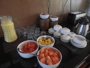 a counter top with bowls of fruit and a blender at Ananterra Resort Wayanad in Wayanad