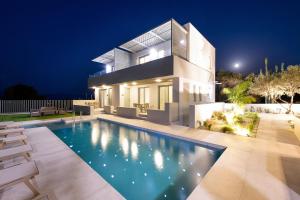 a house with a swimming pool at night at Heliades Residence in Kounoupidhianá