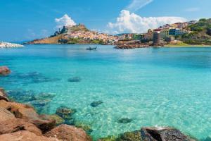 Nulvi的住宿－Porto Cielo Nord Sardegna，享有蓝色海水海滩和建筑的景致