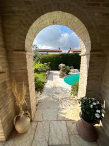 un arco que conduce a un patio trasero con piscina en Damabianca, en Portogruaro