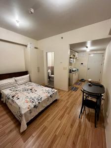 Un dormitorio con una cama y una mesa. en JFam Suites - Studio and 1Bedroom Units!, en Biñan