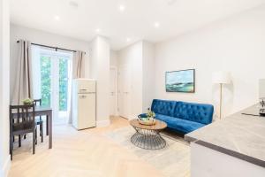 a living room with a blue couch and a table at The Solo Haven 20 Min to Central in London