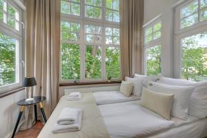 a large white bed in a room with windows at Downtown Apartments Sopot Chopina Seaside in Sopot