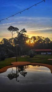 un reflet du coucher de soleil dans un étang dans l'établissement Ecovila Coração da Mata, à Brumadinho